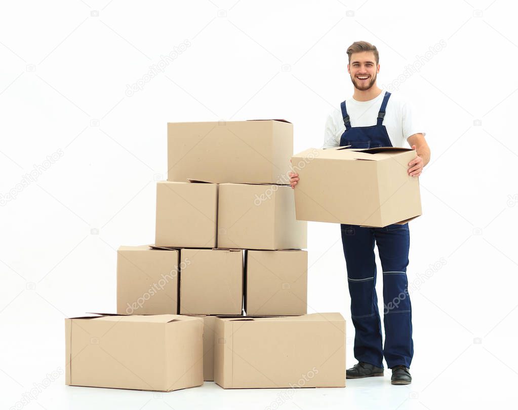 Young man carrying a box to the pile of boxes.