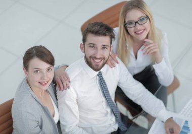 masada oturan ve kameraya bakarak başarılı iş takım.