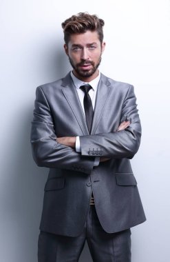 Çapraz kollarla poz veren genç iş adamı.
