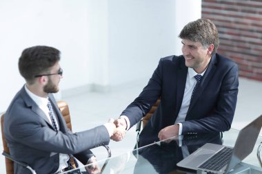 İş adamları el sıkışır, masada otururlar. .