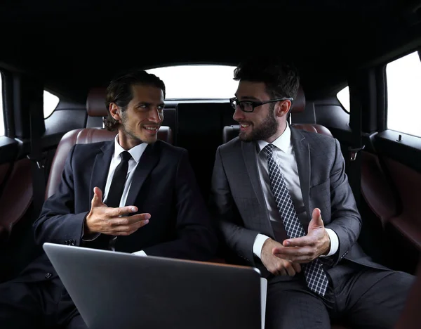 Dos hombres de negocios hablando mientras están sentados en el coche —  Fotos de Stock