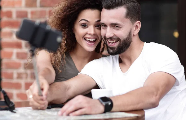 Heureux couple joyeux assis dans un café et faire selfie — Photo
