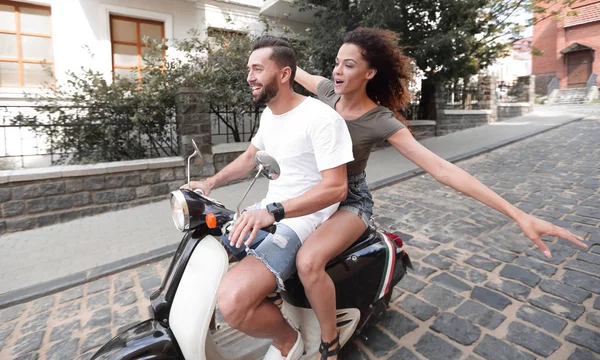 Elegante jovem casal senta-se uma scooter na rua . — Fotografia de Stock