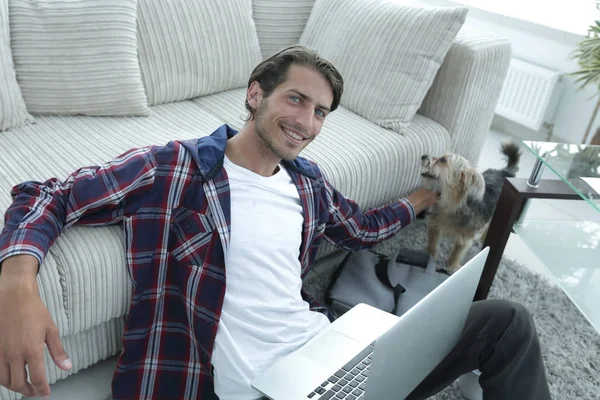 başarılı adam kanepede yakın katta oturan hayvanını okşayarak