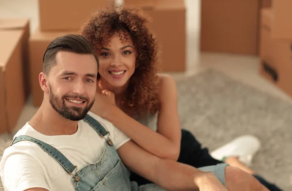 Jovem casal sentado no chão em um novo apartamento — Fotografia de Stock