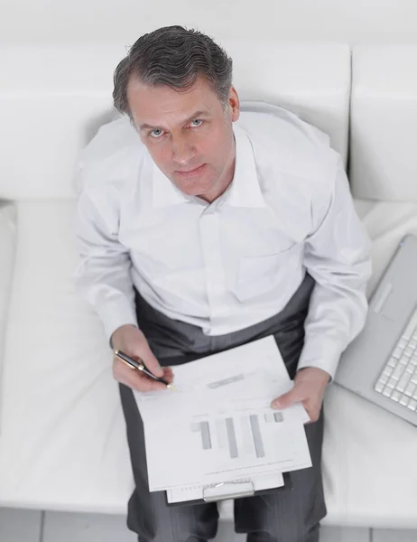Vista desde el top.businessman trabajando con documentos sentados en el sofá —  Fotos de Stock
