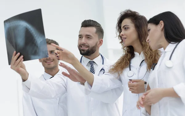 Grupo de trabalhadores médicos olhando para os pacientes filme de raios-x — Fotografia de Stock