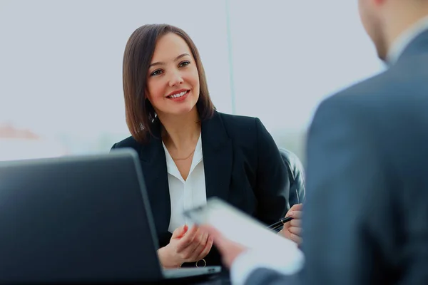 Bela jovem empresária conduzindo uma entrevista de emprego sentada em sua mesa . — Fotografia de Stock