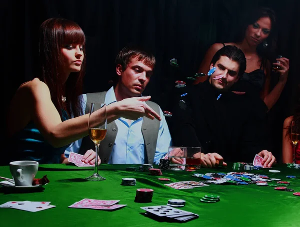 Young women throwing chips on the table while playing cards. — Stock Photo, Image