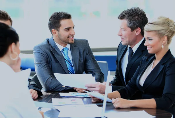 Joven sonriente sentado en una reunión de negocios con sus colegas . — Foto de Stock