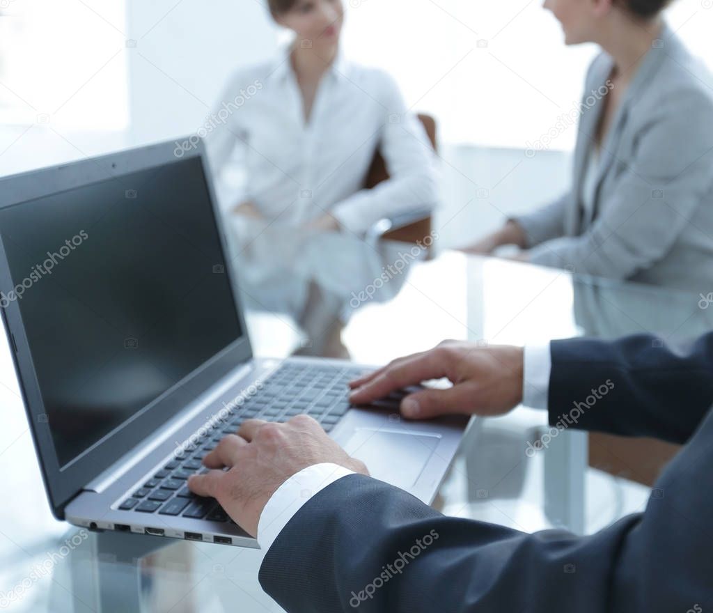 closeup of male hands typing on a laptop.