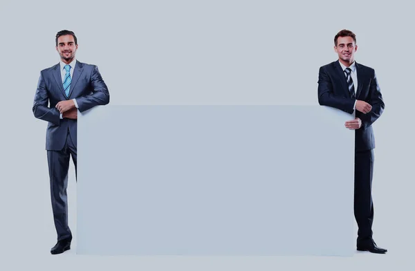 Twee zakenman tonen leeg bord, geïsoleerd op witte achtergrond. — Stockfoto
