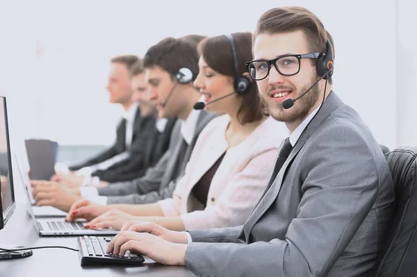 Exploitant callcenter met collega's zitten op de werkplek — Stockfoto