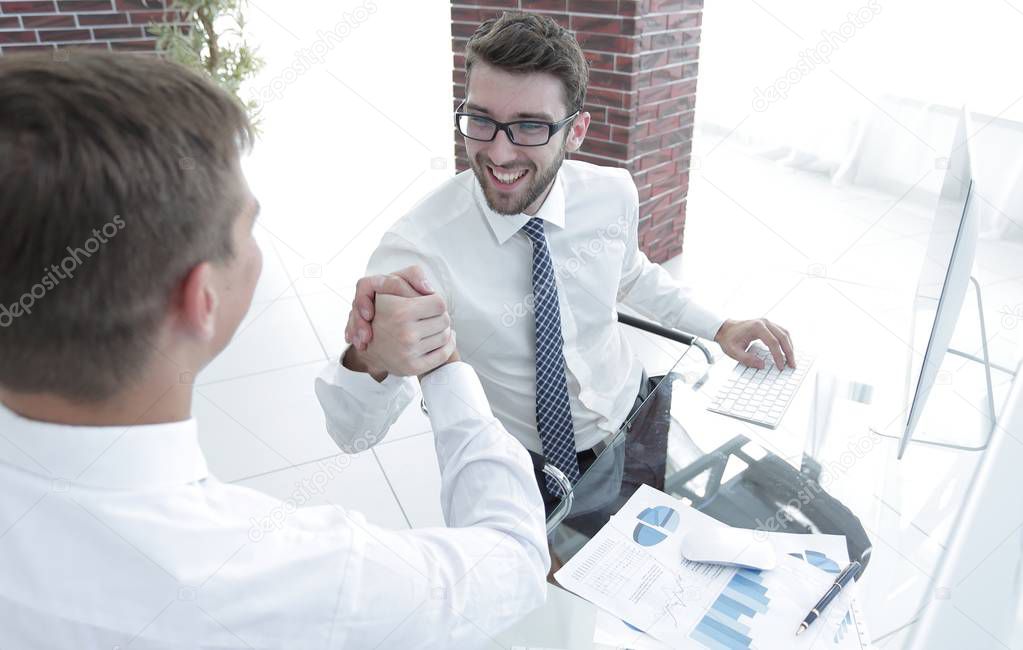 handshake between colleagues at the workplace