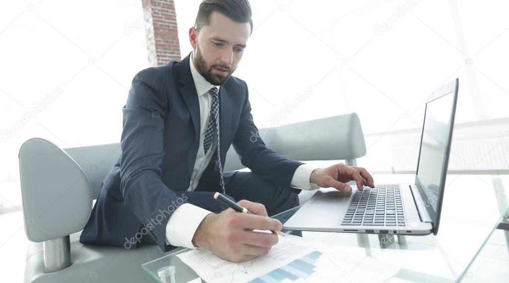 Businessman working with business graphics on a laptop computer
