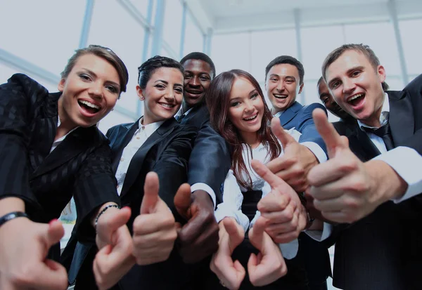 Equipe de negócios multi-étnica feliz com polegares no escritório . — Fotografia de Stock