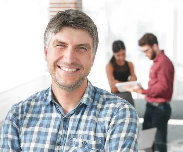 Hombre de negocios casual con los brazos cruzados de pie en la oficina — Foto de Stock