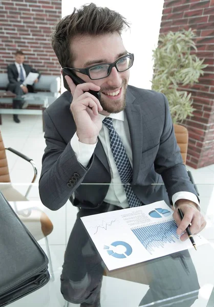 Empresário falando no smartphone em sua mesa — Fotografia de Stock