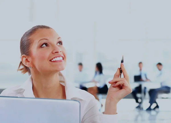 Pensativo sorridente mulher de negócios no fundo de colegas no escritório . — Fotografia de Stock