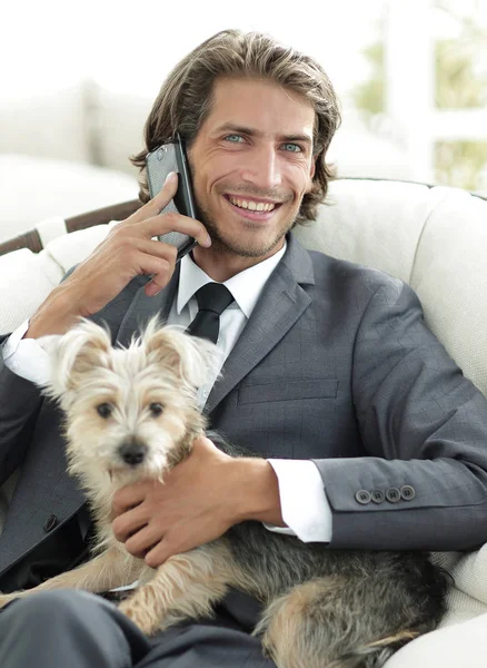 Hombre de negocios hablando por teléfono y sosteniendo a su mascota —  Fotos de Stock