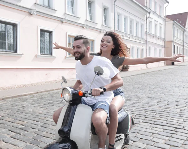 Happy young couple having fun on a scooter — Stock Photo, Image