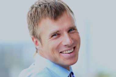 ofisinde gülümseyen genç işadamı portresi.