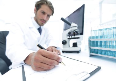 Bilimadamı laboratuarda bir deney notu yazar.
