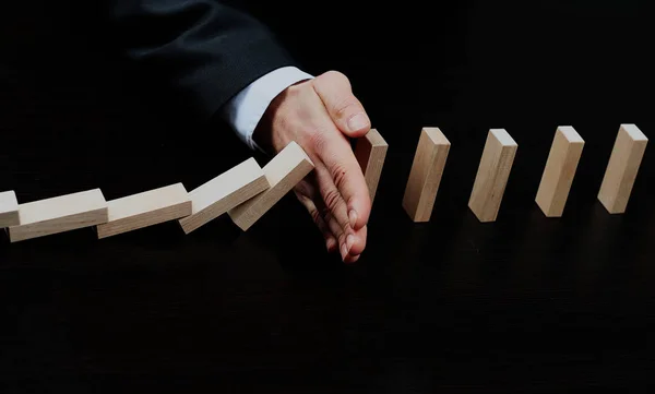 Männerhand legt Holzklötze auf einen Turm. Planung und Strategiekonzept. — Stockfoto