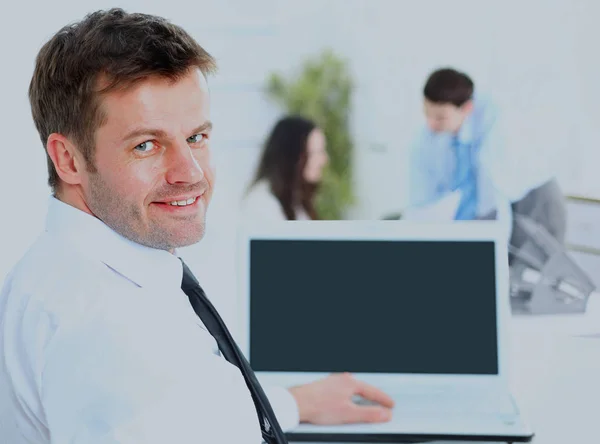 Zakenman zit aan zijn Bureau in het kantoor met een laptop. — Stockfoto