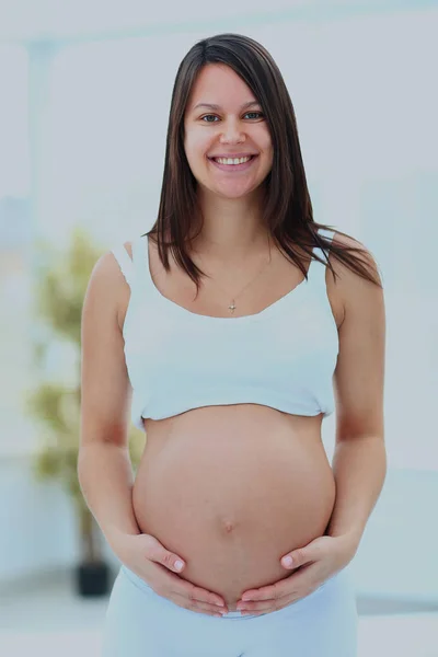 Vrouw houdt haar baby bump. — Stockfoto