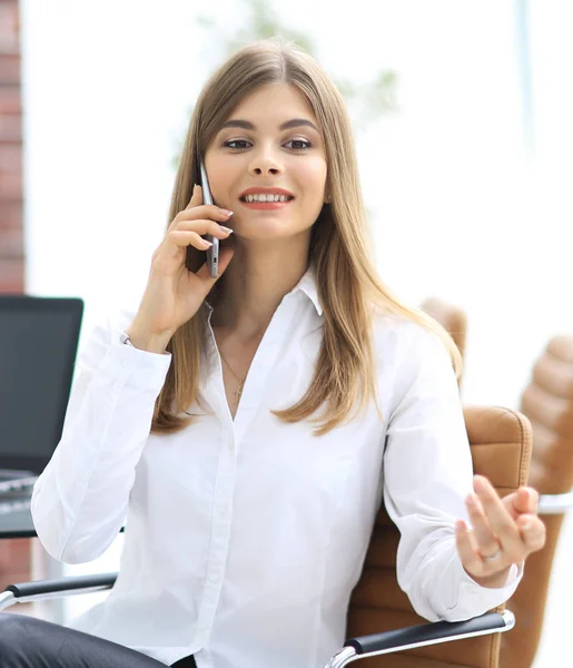 Donna d'affari che parla al cellulare seduta in ufficio — Foto Stock