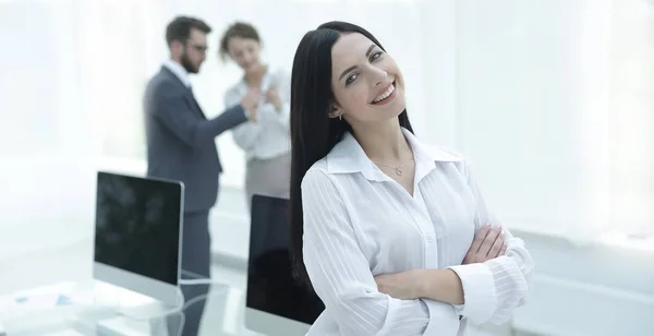 Succesvolle jonge zakenvrouw op de achtergrond van een werkplek — Stockfoto