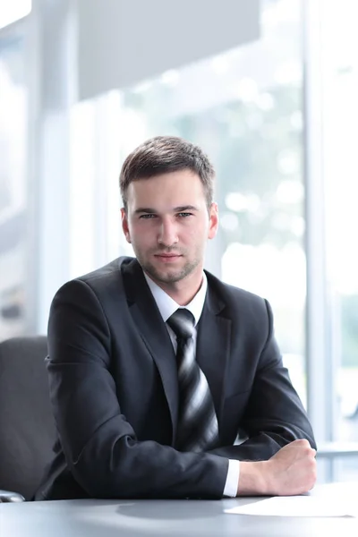 Retrato de hombre de negocios seguro sentado detrás de un escritorio — Foto de Stock