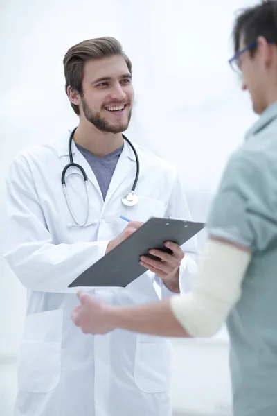 Podiatra escribiendo una receta a su paciente . — Foto de Stock