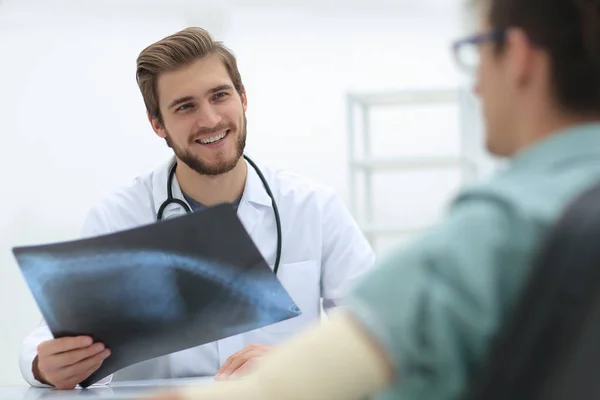 Läkaren undersöker röntgen bild av patienten — Stockfoto