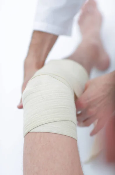 Gros plan. médecin bandage une jambe patients — Photo