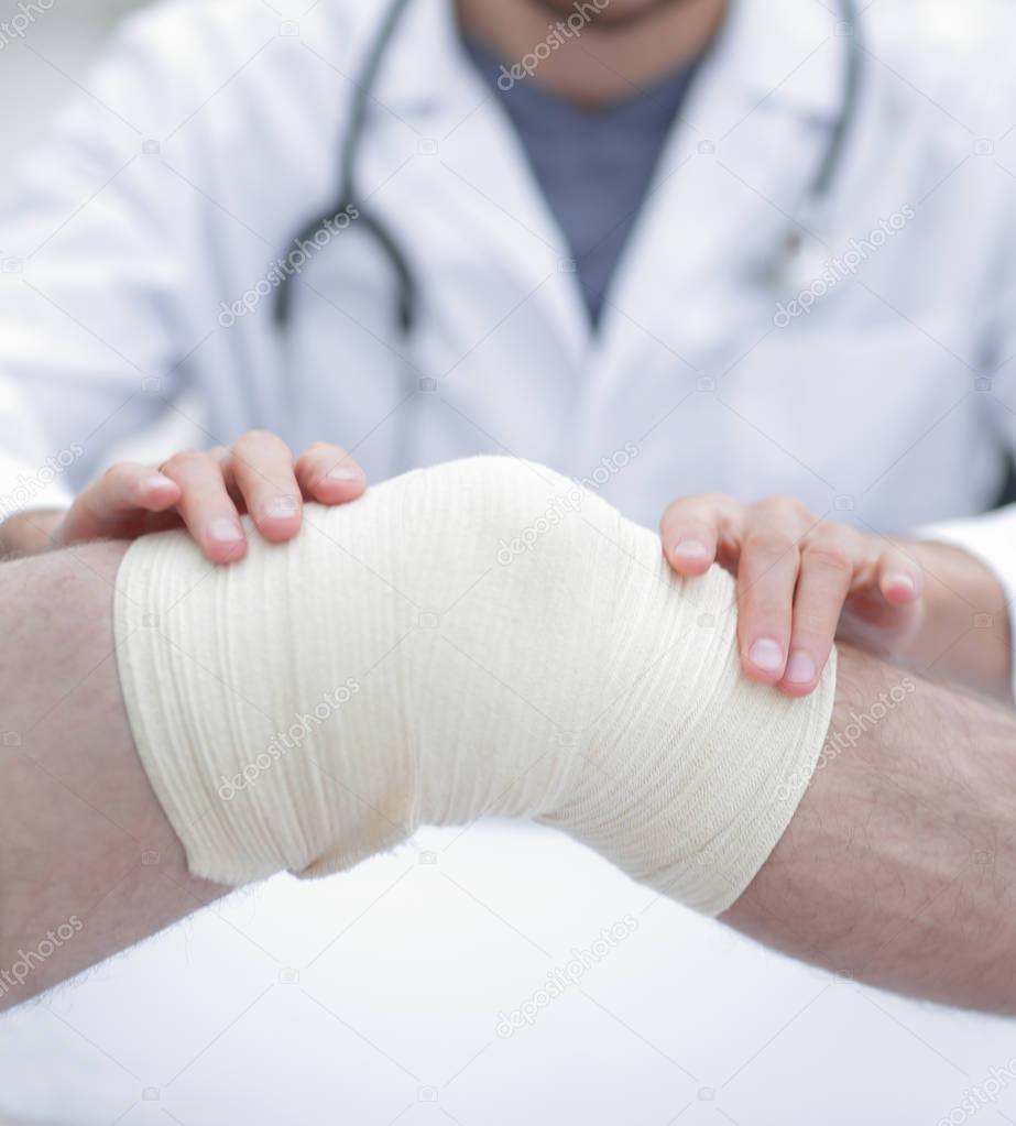 traumatologist ,applying a bandage on the knee