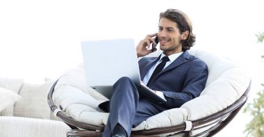 oturma odasında bir smartphone cep telefonu ile konuşurken iş adamı