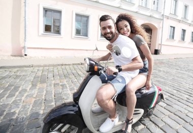 Genç çift bir scooter sürme ve having fun