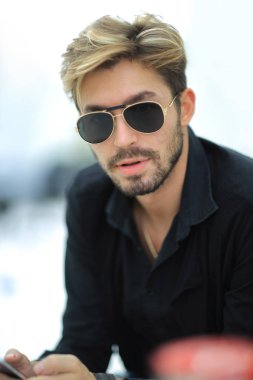 Cep telefonu kullaranarak parkta oturan işadamı