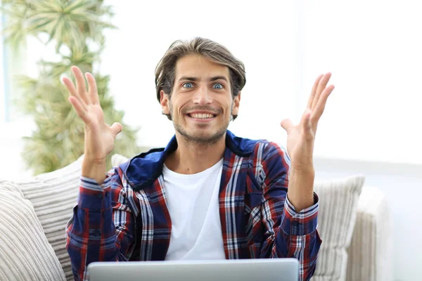 Счастливый успешный молодой человек смотрит на ноутбук дома . — стоковое фото