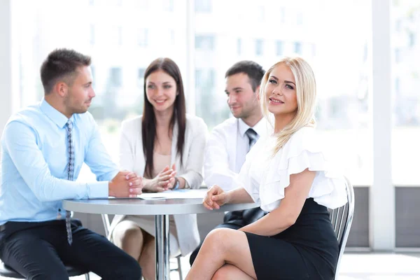 Equipo de negocios sentado en una mesa en un café, en un descanso de trabajo — Foto de Stock