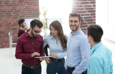 Bir grup insan iş planlarını tabletle tartışıyor..