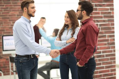 Ofiste meslektaşı ile işadamı el gülümseyen.