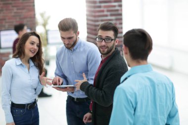 Tablet bilgisayarlı iş ekibi ofiste tartışıyor