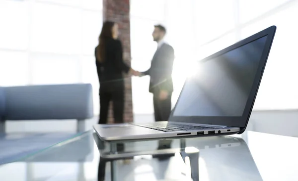 Laptop on the desk, background handshake — Stock Photo, Image