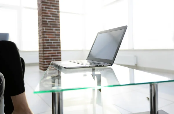 Γραφείο εργασίας με φορητό υπολογιστή σε ένα γυάλινο τραπέζι σε ένα σύγχρονο γραφείο — Φωτογραφία Αρχείου