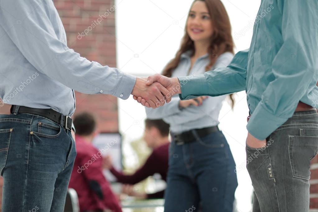 Handshake between businesspeople in a modern office.