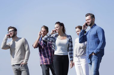 Akıllı telefonları olan bir grup genç.