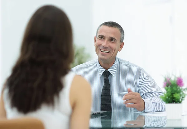 Consultor de negócios senta-se em sua mesa e consultar com seu cliente — Fotografia de Stock